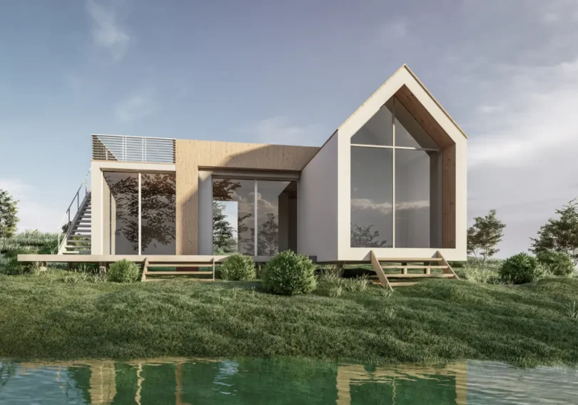 Modern two‑story house with large glass walls and a wooden accent, on a grassy bank by a calm pond.