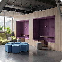 Modern lounge with purple wall niches, blue modular seating, and plants in a coworking space.